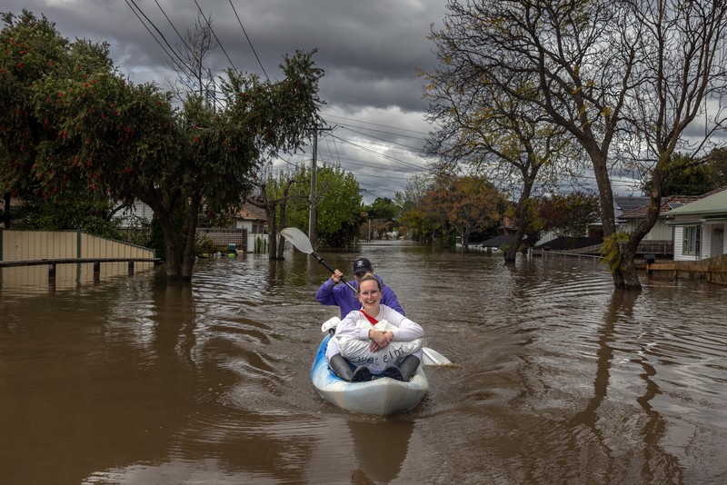 Banjir di Australia Pekerja darurat mengevakuasi warga saat banjir di pinggiran Melbourne, Maribyrnong, Australia, Jumat (14102/2022). Banjir telah menggenangi jalan, memaksa sekolah ditutup, dan memutus aliran listrik ke 3.000 rumah dan bisnis. (Photo by WILLIAM WEST/AFP via Getty Images)
