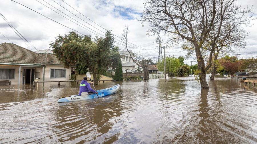 Pekerja darurat mengevakuasi warga saat banjir di pinggiran Melbourne, Maribyrnong, Australia, Jumat (14102/2022). Banjir telah menggenangi jalan, memaksa sekolah ditutup, dan memutus aliran listrik ke 3.000 rumah dan bisnis. (Photo by WILLIAM WEST/AFP via Getty Images)