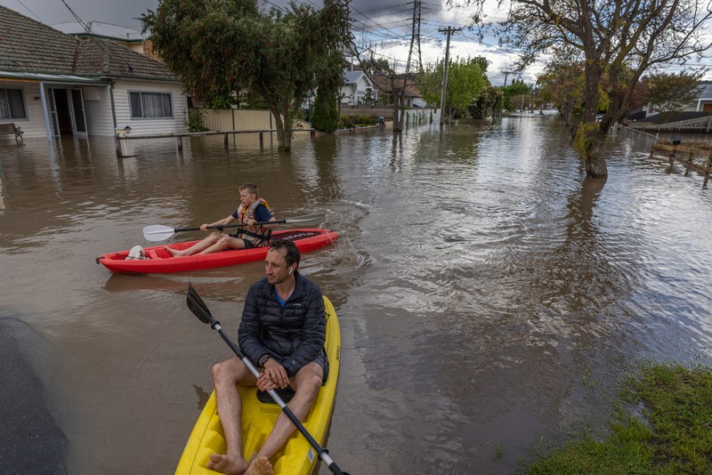 Pekerja darurat mengevakuasi warga saat banjir di pinggiran Melbourne, Maribyrnong, Australia, Jumat (14102/2022). Banjir telah menggenangi jalan, memaksa sekolah ditutup, dan memutus aliran listrik ke 3.000 rumah dan bisnis. (Photo by WILLIAM WEST/AFP via Getty Images)