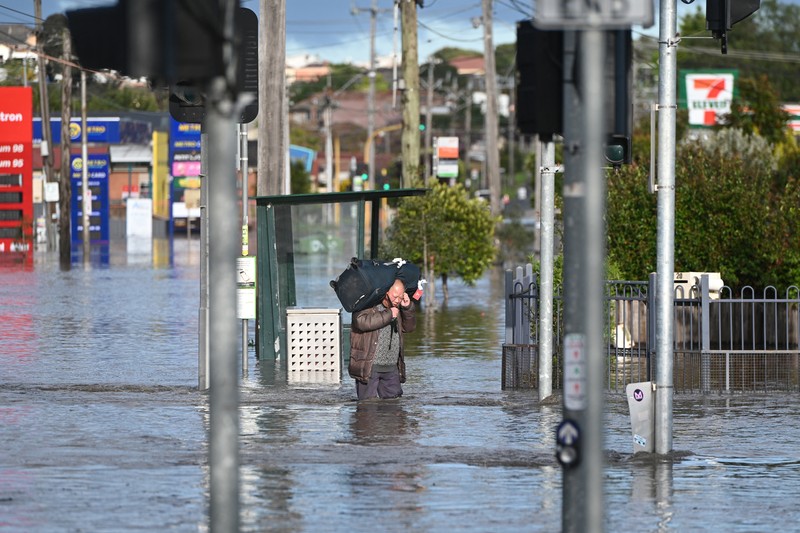 Banjir di Australia Pekerja darurat mengevakuasi warga saat banjir di pinggiran Melbourne, Maribyrnong, Australia, Jumat (14102/2022). Banjir telah menggenangi jalan, memaksa sekolah ditutup, dan memutus aliran listrik ke 3.000 rumah dan bisnis. (Photo by WILLIAM WEST/AFP via Getty Images)