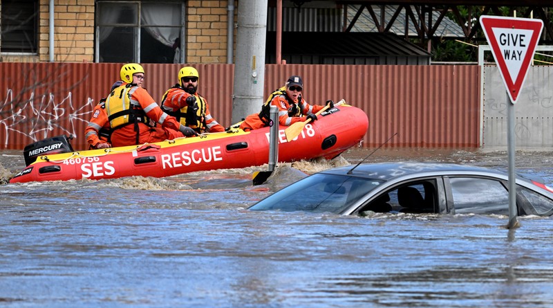 Pekerja darurat mengevakuasi warga saat banjir di pinggiran Melbourne, Maribyrnong, Australia, Jumat (14102/2022). Banjir telah menggenangi jalan, memaksa sekolah ditutup, dan memutus aliran listrik ke 3.000 rumah dan bisnis. (Photo by WILLIAM WEST/AFP via Getty Images)