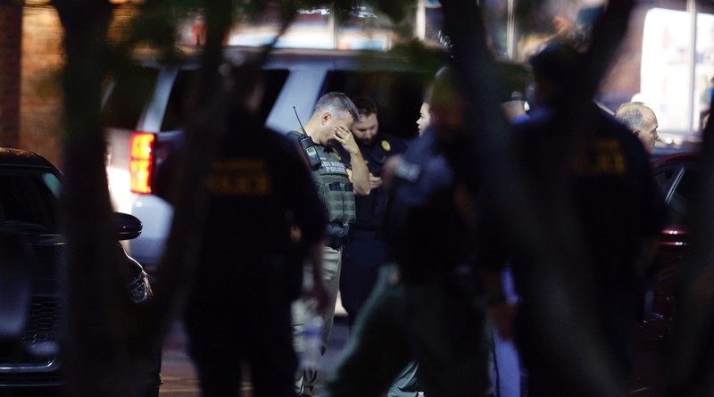 Petugas Polisi Raleigh berjalan dari pintu ke pintu memeriksa penduduk di lingkungan Hedingham dan daerah Jalur Sungai Neuse di Raleigh, North Carolina. Kamis malam (13/10/2022). Sedikitnya lima orang tewas dalam insiden penembakan brutal yang terjadi sekitar pukul 17.00 waktu setempat, di dekat Jalur Hijau Sungai Neus. Atas kejadiaan tersebut satu orang telah ditangkap. (Travis Long/The News & Observer via AP)