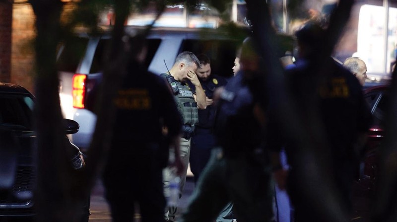 Petugas Polisi Raleigh berjalan dari pintu ke pintu memeriksa penduduk di lingkungan Hedingham dan daerah Jalur Sungai Neuse di Raleigh, North Carolina. Kamis malam (13/10/2022). Sedikitnya lima orang tewas dalam insiden penembakan brutal yang terjadi sekitar pukul 17.00 waktu setempat, di dekat Jalur Hijau Sungai Neus. Atas kejadiaan tersebut satu orang telah ditangkap. (Travis Long/The News & Observer via AP)