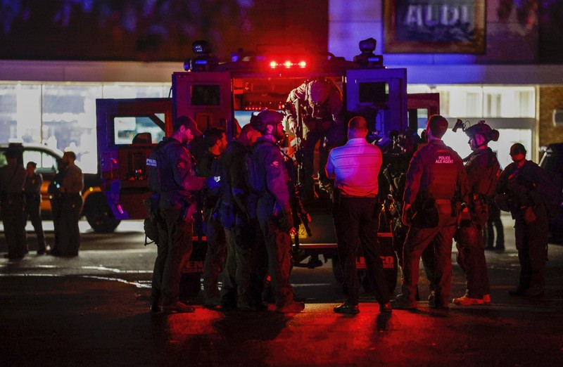 Petugas Polisi Raleigh berjalan dari pintu ke pintu memeriksa penduduk di lingkungan Hedingham dan daerah Jalur Sungai Neuse di Raleigh, North Carolina. Kamis malam (13/10/2022). Sedikitnya lima orang tewas dalam insiden penembakan brutal yang terjadi sekitar pukul 17.00 waktu setempat, di dekat Jalur Hijau Sungai Neus. Atas kejadiaan tersebut satu orang telah ditangkap. (Travis Long/The News & Observer via AP)