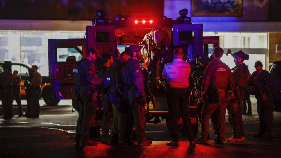 Petugas Polisi Raleigh berjalan dari pintu ke pintu memeriksa penduduk di lingkungan Hedingham dan daerah Jalur Sungai Neuse di Raleigh, North Carolina. Kamis malam (13/10/2022). Sedikitnya lima orang tewas dalam insiden penembakan brutal yang terjadi sekitar pukul 17.00 waktu setempat, di dekat Jalur Hijau Sungai Neus. Atas kejadiaan tersebut satu orang telah ditangkap. (Travis Long/The News & Observer via AP)