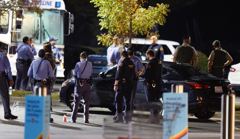 Penmebakan di Raleigh, North Carolina, Amerika Serikat Petugas Polisi Raleigh berjalan dari pintu ke pintu memeriksa penduduk di lingkungan Hedingham dan daerah Jalur Sungai Neuse di Raleigh, North Carolina. Kamis malam (13/10/2022). Sedikitnya lima orang tewas dalam insiden penembakan brutal yang terjadi sekitar pukul 17.00 waktu setempat, di dekat Jalur Hijau Sungai Neus. Atas kejadiaan tersebut satu orang telah ditangkap. (Travis Long/The News & Observer via AP)