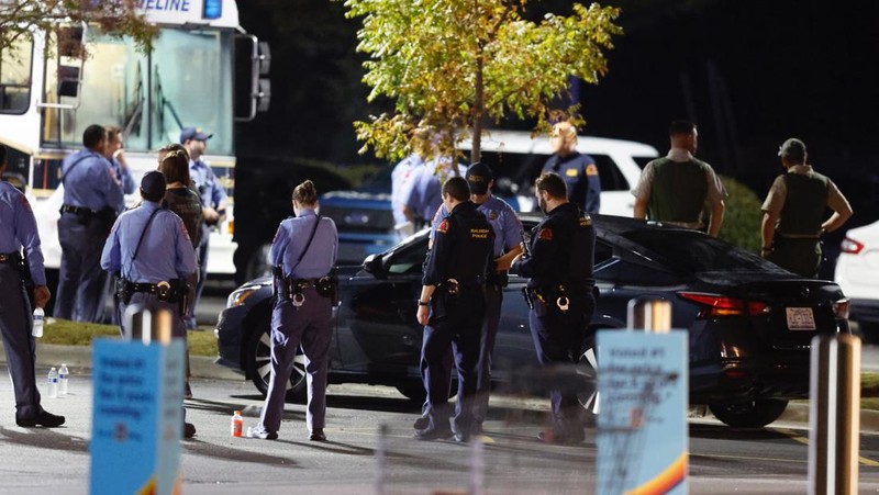 Petugas Polisi Raleigh berjalan dari pintu ke pintu memeriksa penduduk di lingkungan Hedingham dan daerah Jalur Sungai Neuse di Raleigh, North Carolina. Kamis malam (13/10/2022). Sedikitnya lima orang tewas dalam insiden penembakan brutal yang terjadi sekitar pukul 17.00 waktu setempat, di dekat Jalur Hijau Sungai Neus. Atas kejadiaan tersebut satu orang telah ditangkap. (Travis Long/The News & Observer via AP)