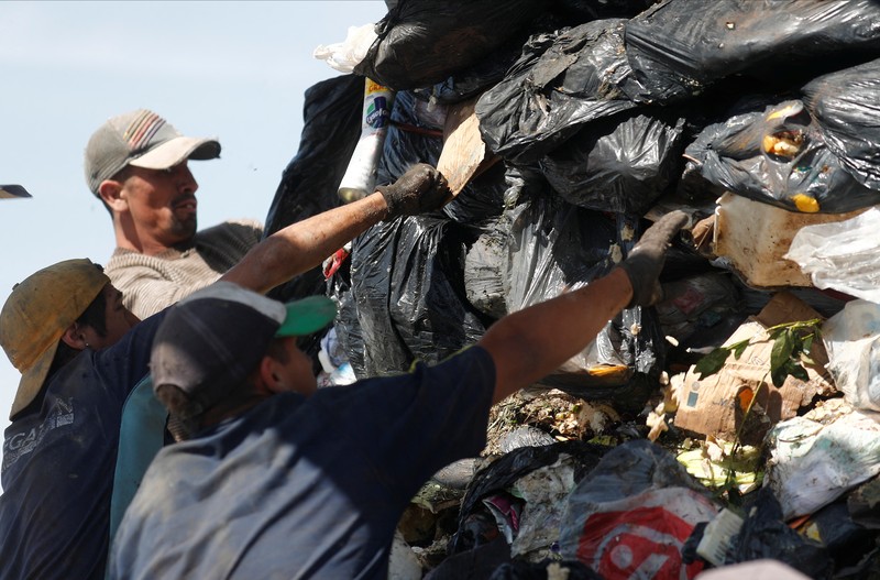Waste recyclers look through heaps of waste at a landfill for cardboard, plastic and metal, which they sell while working 12-hour shifts, as Argentina faces one of the world's highest inflation rates, set to top 100% this year, in Lujan, on the outskirts of Buenos Aires, Argentina October 5, 2022. REUTERS/Agustin Marcarian