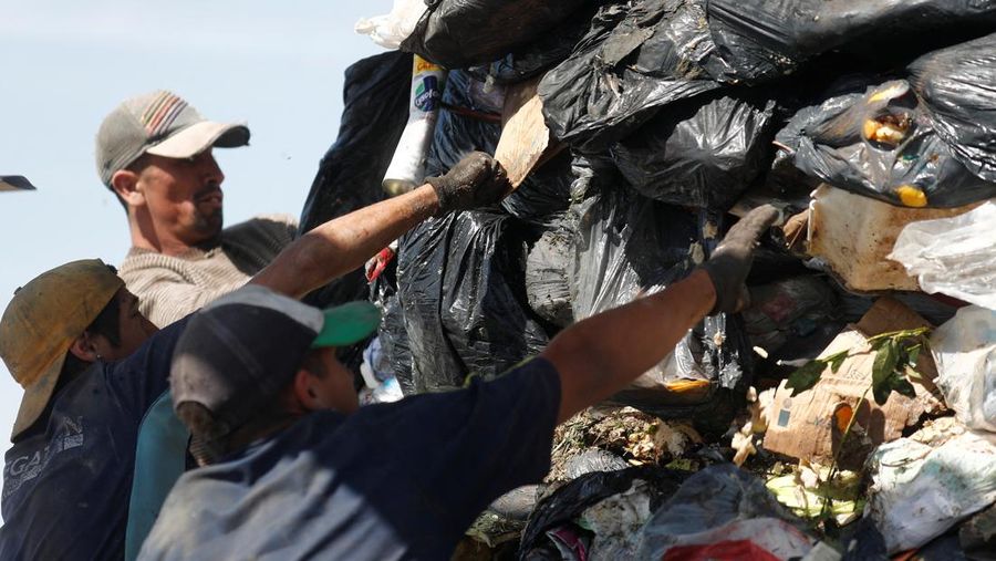 Waste recyclers look through heaps of waste at a landfill for cardboard, plastic and metal, which they sell while working 12-hour shifts, as Argentina faces one of the world's highest inflation rates, set to top 100% this year, in Lujan, on the outskirts of Buenos Aires, Argentina October 5, 2022. REUTERS/Agustin Marcarian