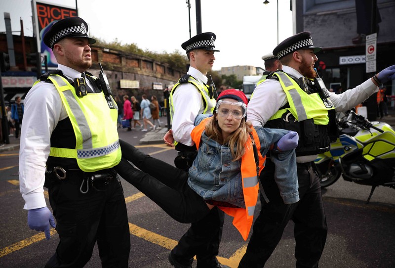 A member of the public drags an activist who is blocking the road during a 