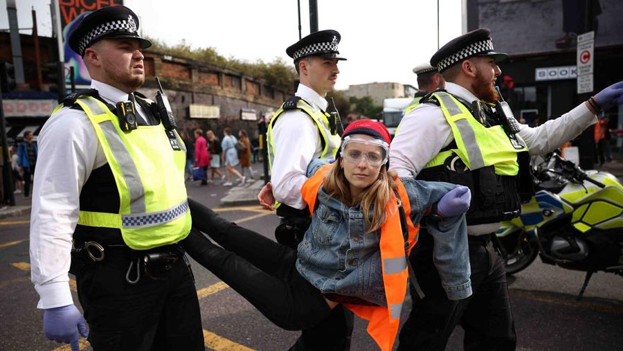 A member of the public drags an activist who is blocking the road during a 