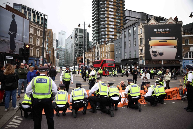 A member of the public drags an activist who is blocking the road during a 