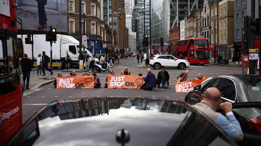 A member of the public drags an activist who is blocking the road during a 