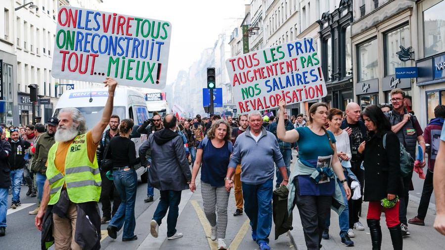 Ribuan orang menggelar protes menentang biaya hidup dan ketidakpekaan pemerintah terhadap perang melawan perubahan iklim di Paris, Prancis , Minggu (16/10/2022). Selain berdemo soal inflasi, mereka mengkritik kebijakan pemerintah soal energi, barang-barang penting dan sewa, serta pajak yang lebih besar dari keuntungan tak terduga oleh perusahaan. Di kesempatan yang sama, mereka juga menyerukan investasi besar-besaran melawan krisis iklim. (Photo by Vincent Koebel/Anadolu Agency via Getty Images)