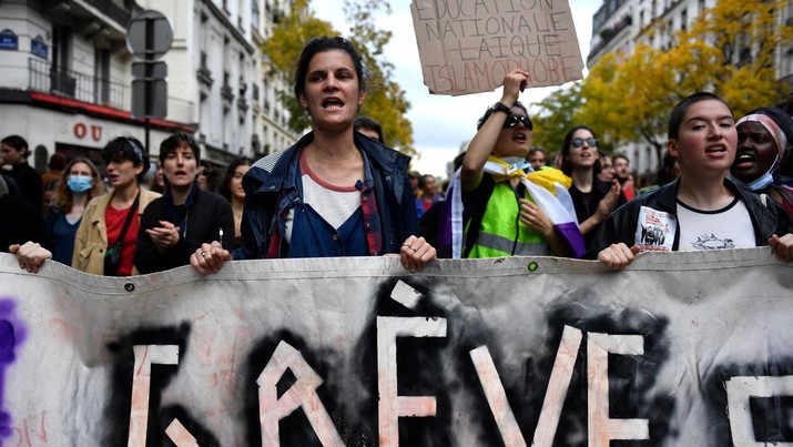 Demo Inflasi dan Krisis Iklim di Paris Prancis Para pengunjuk rasa memegang spanduk bertuliskan 'mogok' saat melakukan aksi menentang melonjaknya biaya hidup yang diserukan oleh koalisi sayap kiri Prancis NUPES (Persatuan Ekologi dan Sosial Rakyat Baru) di Paris, Prancis , Minggu (16/10/2022). Selain berdemo soal inflasi, mereka mengkritik kebijakan pemerintah soal energi, barang-barang penting dan sewa, serta pajak yang lebih besar dari keuntungan tak terduga oleh perusahaan. Di kesempatan yang sama, mereka juga menyerukan investasi besar-besaran melawan krisis iklim. (Photo by JULIEN DE ROSA/AFP via Getty Images)