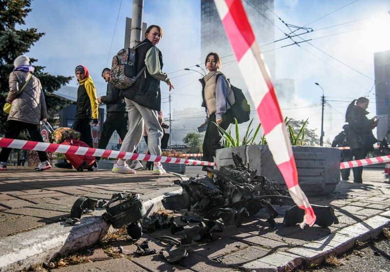 Seorang petugas polisi menembaki pesawat tak berawak Rusia (drone) yang terbang setelah serangan di Kyiv, Ukraina, Senin (17/10/2022)  Menurut Kantor Kepresidenan Ukraina, serangan dilakukan pesawat tanpa awak (UAV) Shahed-136, kamikaze buatan Iran. Belum diketahui sejauh mana kerusakan dan korban. (Photo by YASUYOSHI CHIBA/AFP via Getty Images)