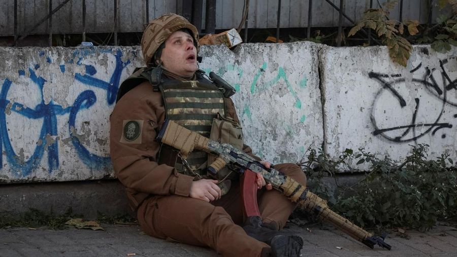 Seorang prajurit Ukraina berlindung saat sirene serangan udara berbunyi selama serangan pesawat tak berawak Rusia di Kyiv, Ukraina, Senin (17/10/2022)  Menurut Kantor Kepresidenan Ukraina, serangan dilakukan pesawat tanpa awak (UAV) Shahed-136, kamikaze buatan Iran. Belum diketahui sejauh mana kerusakan dan korban. (REUTERS/Gleb Garanich)