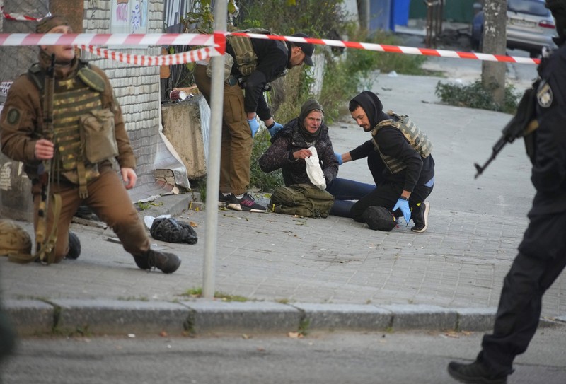 Seorang petugas polisi menembaki pesawat tak berawak Rusia (drone) yang terbang setelah serangan di Kyiv, Ukraina, Senin (17/10/2022)  Menurut Kantor Kepresidenan Ukraina, serangan dilakukan pesawat tanpa awak (UAV) Shahed-136, kamikaze buatan Iran. Belum diketahui sejauh mana kerusakan dan korban. (Photo by YASUYOSHI CHIBA/AFP via Getty Images)