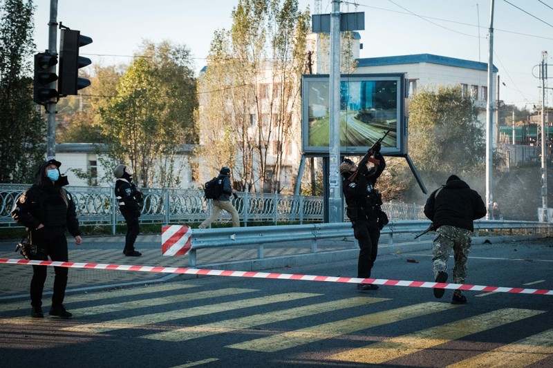 Seorang petugas polisi menembaki pesawat tak berawak Rusia (drone) yang terbang setelah serangan di Kyiv, Ukraina, Senin (17/10/2022)  Menurut Kantor Kepresidenan Ukraina, serangan dilakukan pesawat tanpa awak (UAV) Shahed-136, kamikaze buatan Iran. Belum diketahui sejauh mana kerusakan dan korban. (Photo by YASUYOSHI CHIBA/AFP via Getty Images)