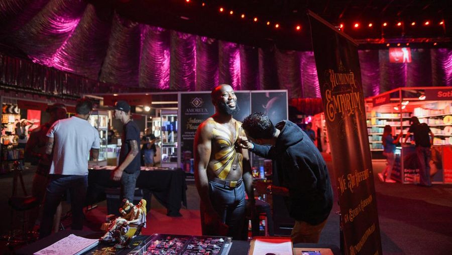 Petarung MMA Aben Khoza melukis tubuhnya di The Sex Expo, pameran bertema dewasa yang diadakan di Pretoria, Afrika Selatan, Kamis (13/10/2022). (REUTERS/Alet Pretorius)