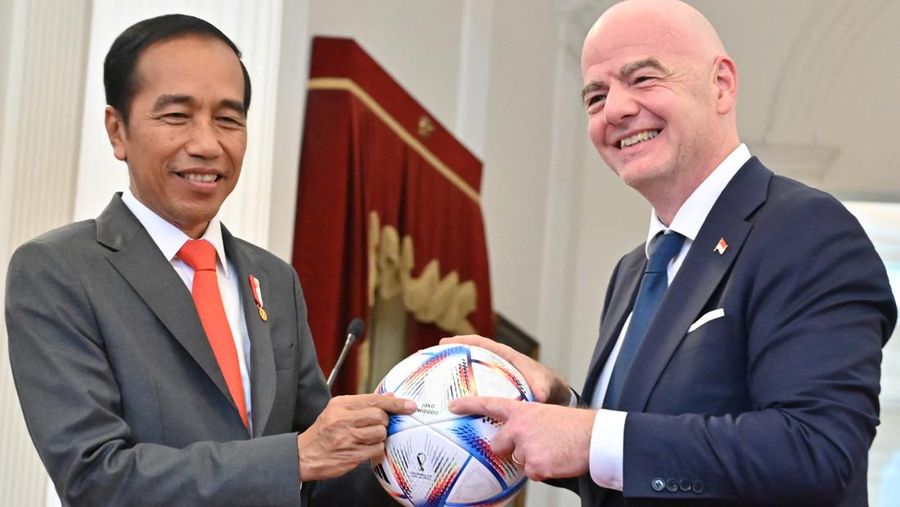 Presiden badan sepak bola dunia FIFA, Gianni Infantino (kanan) menyerahkan bola kepada Presiden Indonesia Joko Widodo (kiri) usai memberikan keterangan pers hasil pertemuan mereka di Istana Merdeka di Jakarta, Indonesia, Selasa (18/10/2022). (Photo by ADEK BERRY/AFP via Getty Images)