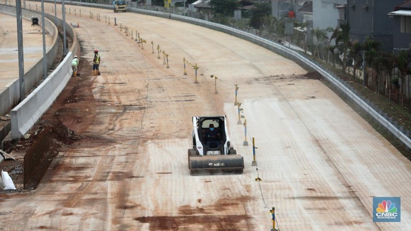 Pekerja menyelesaikan pembangunan Tol Cinere - Jagorawi (Cijago) seksi III di Beji, Depok, Jawa Barat, Jumat (8/7/2022). Jalan tol tersebut merupakan bagian dari jaringan Jalan Tol Jakarta Outer Ring Road atau JORR II yang menghubungkan Kukusan–Cinere Depok sepanjang 5,5 kilometer. (CNBC Indoneia/ Tri Susilo)