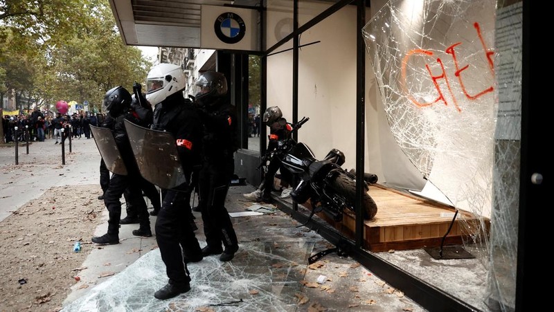 A demonstrator destroys a bank window during clashes at a demonstration in Paris as part of a nationwide day of strike and protests for higher wages and against requisitions at refineries in France, October 18, 2022.  REUTERS/Benoit Tessier