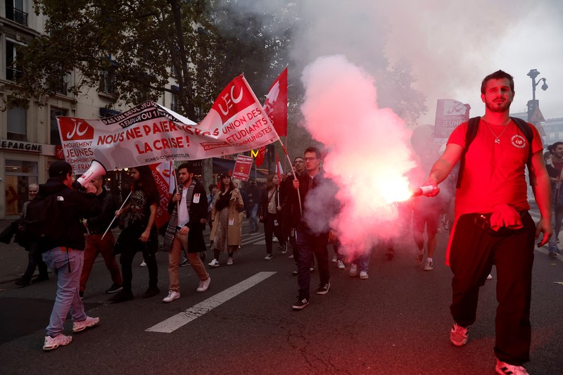 A demonstrator destroys a bank window during clashes at a demonstration in Paris as part of a nationwide day of strike and protests for higher wages and against requisitions at refineries in France, October 18, 2022.  REUTERS/Benoit Tessier