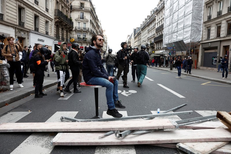A demonstrator destroys a bank window during clashes at a demonstration in Paris as part of a nationwide day of strike and protests for higher wages and against requisitions at refineries in France, October 18, 2022.  REUTERS/Benoit Tessier