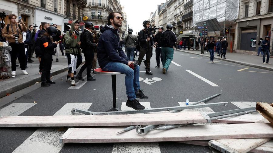 A demonstrator destroys a bank window during clashes at a demonstration in Paris as part of a nationwide day of strike and protests for higher wages and against requisitions at refineries in France, October 18, 2022.  REUTERS/Benoit Tessier