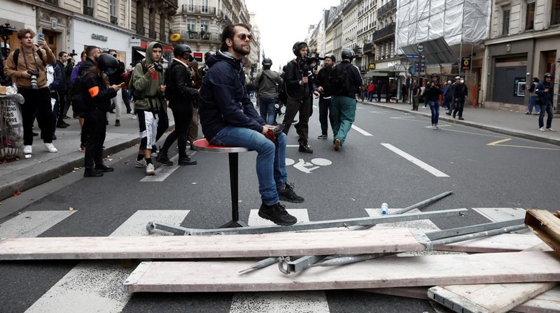 A demonstrator destroys a bank window during clashes at a demonstration in Paris as part of a nationwide day of strike and protests for higher wages and against requisitions at refineries in France, October 18, 2022.  REUTERS/Benoit Tessier