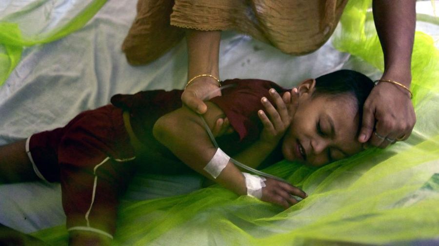A woman comforts a child suffering from dengue fever at a government hospital in Dhaka on October 19, 2022. (Photo by Munir uz ZAMAN / AFP) (Photo by MUNIR UZ ZAMAN/AFP via Getty Images)