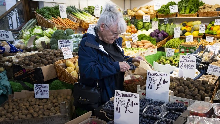 CARDIFF, WALES - OCTOBER 19: A woman shops in a greengrocers in Cardiff Market on October 19, 2022 in Cardiff, United Kingdom. The Office for National Statistics (ONS) said the consumer prices index (CPI) measure rose from an annual rate of 9.9% in August to match the recent 40-year high of 10.1% seen in July. The largest contributing factor being the rise in food costs. (Photo by Matthew Horwood/Getty Images)