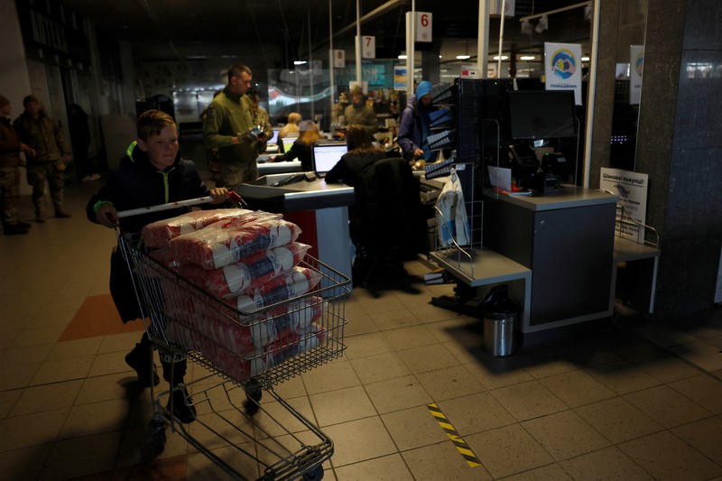 UKRAINE-CRISIS/KHARKIV People shop in a supermarket as Kharkiv suffers an electricity outage, amid Russia's attack on Ukraine, in Kharkiv, Ukraine, October 17, 2022. REUTERS/Clodagh Kilcoyne