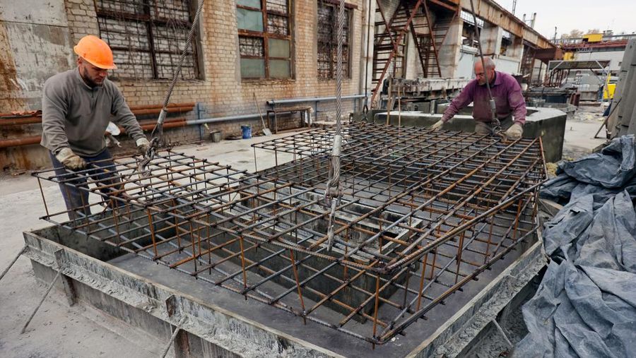 KHARKIV, UKRAINE - OCTOBER 19, 2022 - Men are seen during the production of the components for a concrete bomb shelter, Kharkiv, norheastern Ukraine. (Photo credit should read Vyacheslav Madiyevskyi / Ukrinform/Future Publishing via Getty Images)