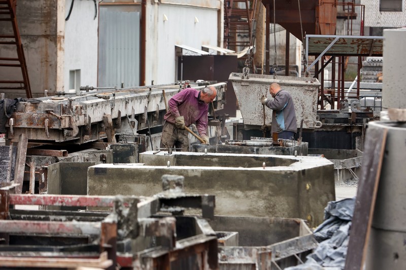1244096129 KHARKIV, UKRAINE - OCTOBER 19, 2022 - Men are seen during the production of the components for a concrete bomb shelter, Kharkiv, norheastern Ukraine. (Photo credit should read Vyacheslav Madiyevskyi / Ukrinform/Future Publishing via Getty Images)
