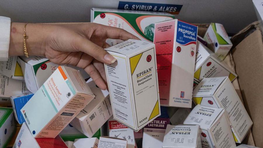 KENDARI, SOUTH EAST SULAWESI, INDONESIA - 2022/10/20: A pharmacist unloads a line of syrup-type drugs from a sales shelf at a pharmacy. Ministry of Health gave instructions not to give or temporarily prescribe drugs over-the-counter in the form of syrup to the public due to atypical cases of progressive acute kidney failure is occurring in children in Indonesia. (Photo by Andry Denisah/SOPA Images/LightRocket via Getty Images)