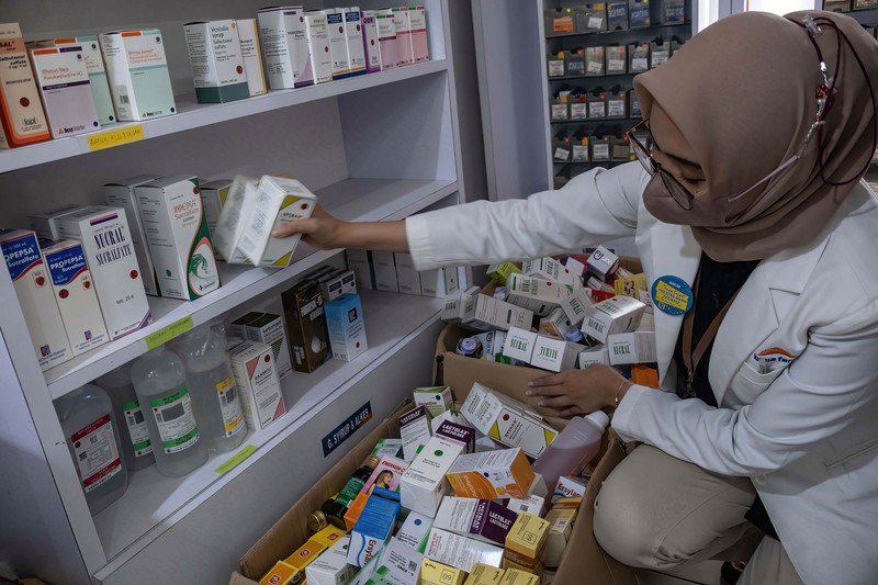 KENDARI, SOUTH EAST SULAWESI, INDONESIA - 2022/10/20: A pharmacist unloads a line of syrup-type drugs from a sales shelf at a pharmacy. Ministry of Health gave instructions not to give or temporarily prescribe drugs over-the-counter in the form of syrup to the public due to atypical cases of progressive acute kidney failure is occurring in children in Indonesia. (Photo by Andry Denisah/SOPA Images/LightRocket via Getty Images)