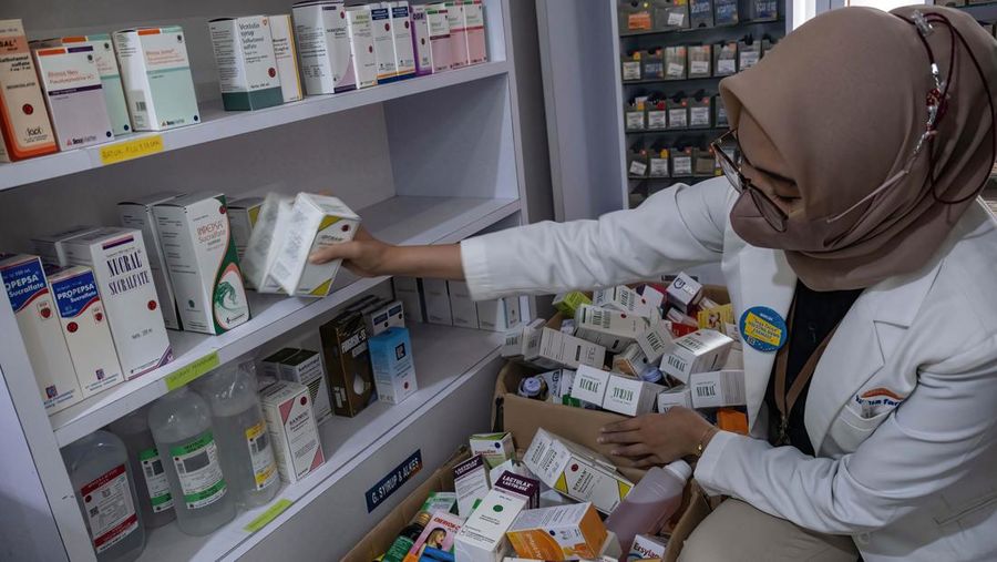KENDARI, SOUTH EAST SULAWESI, INDONESIA - 2022/10/20: A pharmacist unloads a line of syrup-type drugs from a sales shelf at a pharmacy. Ministry of Health gave instructions not to give or temporarily prescribe drugs over-the-counter in the form of syrup to the public due to atypical cases of progressive acute kidney failure is occurring in children in Indonesia. (Photo by Andry Denisah/SOPA Images/LightRocket via Getty Images)