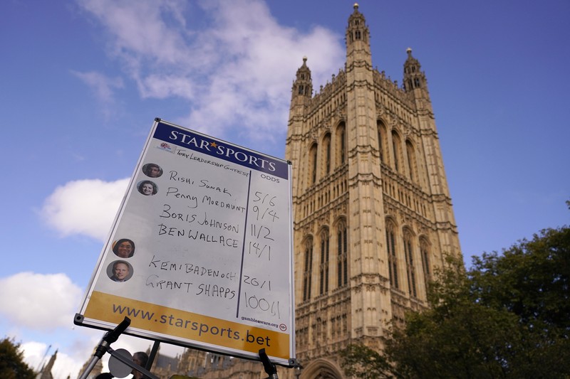 A bookmaker takes bets for the next British Prime Minister after Liz Truss resigned in London, Thursday, Oct. 20, 2022. Truss resigned Thursday, bowing to the inevitable after a tumultuous, short-lived term in which her policies triggered turmoil in financial markets and a rebellion in her party that obliterated her authority.(AP Photo/David Cliff)