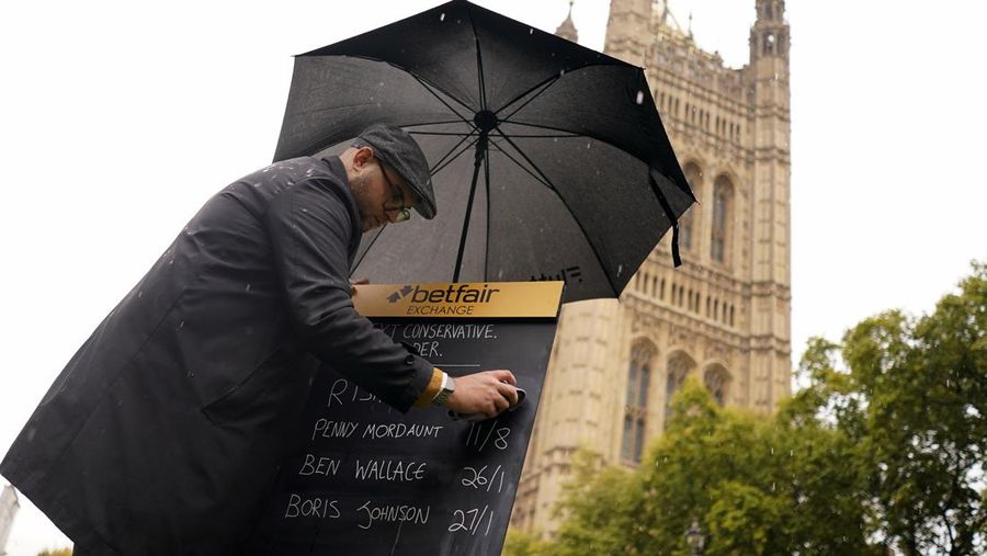 A bookmaker takes bets for the next British Prime Minister after Liz Truss resigned in London, Thursday, Oct. 20, 2022. Truss resigned Thursday, bowing to the inevitable after a tumultuous, short-lived term in which her policies triggered turmoil in financial markets and a rebellion in her party that obliterated her authority.(AP Photo/Alberto Pezzali)