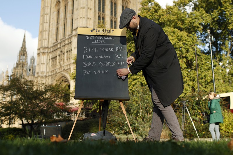 Britain Politics A bookmaker takes bets for the next British Prime Minister after Liz Truss resigned in London, Thursday, Oct. 20, 2022. Truss resigned Thursday, bowing to the inevitable after a tumultuous, short-lived term in which her policies triggered turmoil in financial markets and a rebellion in her party that obliterated her authority.(AP Photo/David Cliff)
