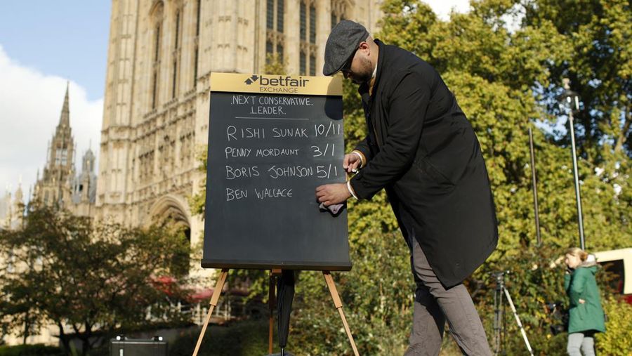 A bookmaker takes bets for the next British Prime Minister after Liz Truss resigned in London, Thursday, Oct. 20, 2022. Truss resigned Thursday, bowing to the inevitable after a tumultuous, short-lived term in which her policies triggered turmoil in financial markets and a rebellion in her party that obliterated her authority.(AP Photo/David Cliff)