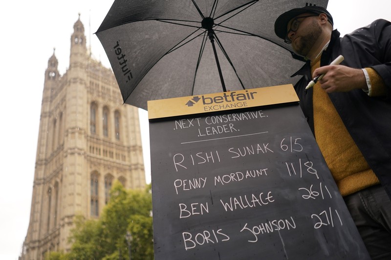 A bookmaker takes bets for the next British Prime Minister after Liz Truss resigned in London, Thursday, Oct. 20, 2022. Truss resigned Thursday, bowing to the inevitable after a tumultuous, short-lived term in which her policies triggered turmoil in financial markets and a rebellion in her party that obliterated her authority.(AP Photo/David Cliff)