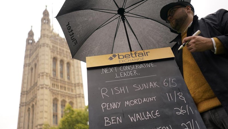 A bookmaker takes bets for the next British Prime Minister after Liz Truss resigned in London, Thursday, Oct. 20, 2022. Truss resigned Thursday, bowing to the inevitable after a tumultuous, short-lived term in which her policies triggered turmoil in financial markets and a rebellion in her party that obliterated her authority.(AP Photo/David Cliff)