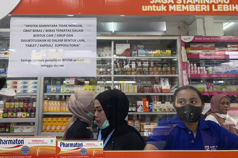 KENDARI, SOUTH EAST SULAWESI, INDONESIA - 2022/10/20: A pharmacist unloads a line of syrup-type drugs from a sales shelf at a pharmacy. Ministry of Health gave instructions not to give or temporarily prescribe drugs over-the-counter in the form of syrup to the public due to atypical cases of progressive acute kidney failure is occurring in children in Indonesia. (Photo by Andry Denisah/SOPA Images/LightRocket via Getty Images)