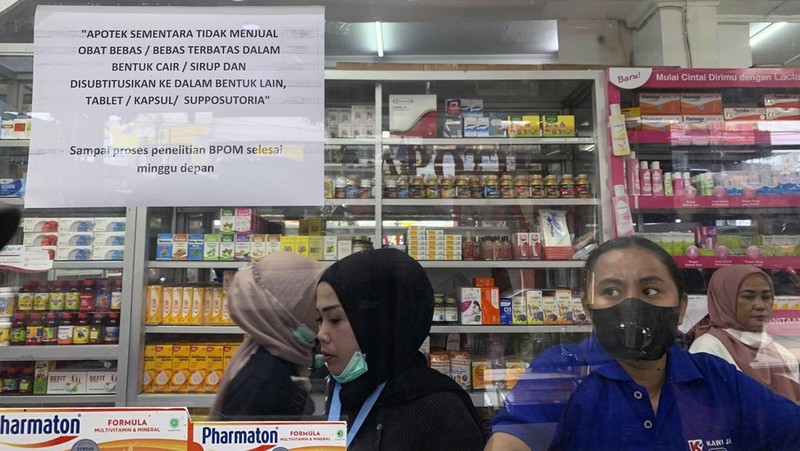 KENDARI, SOUTH EAST SULAWESI, INDONESIA - 2022/10/20: A pharmacist unloads a line of syrup-type drugs from a sales shelf at a pharmacy. Ministry of Health gave instructions not to give or temporarily prescribe drugs over-the-counter in the form of syrup to the public due to atypical cases of progressive acute kidney failure is occurring in children in Indonesia. (Photo by Andry Denisah/SOPA Images/LightRocket via Getty Images)