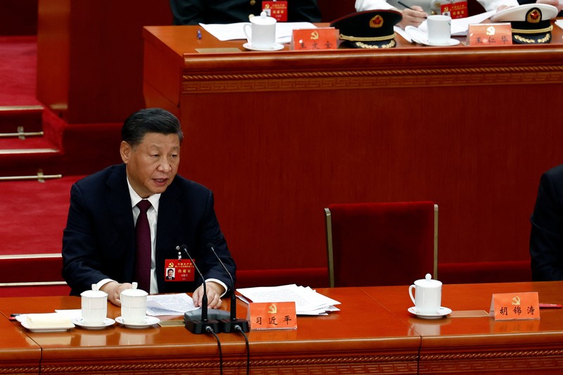 Presiden Tiongkok Xi Jinping, kanan, mendengarkan bantuan saat dia duduk di sebelah Perdana Menteri Li Keqiang selama sesi penutupan Kongres Nasional Partai Komunis Tiongkok ke-20, di Aula Besar Rakyat pada Oktober 22, 2022 di Beijing, Cina. (Getty Images/Kevin Frayer)