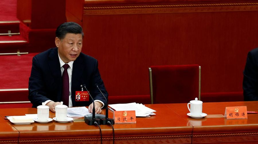 Presiden China Xi Jinping berbicara di sebelah kursi mantan presiden China Hu Jintao saat upacara penutupan Kongres Nasional ke-20 Partai Komunis China, di Aula Besar Rakyat di Beijing, China 22 Oktober 2022. (REUTERS/TINGSHU WANG)