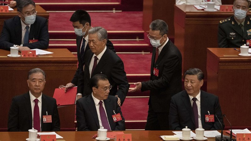 Presiden Tiongkok Xi Jinping, kanan, mendengarkan bantuan saat dia duduk di sebelah Perdana Menteri Li Keqiang selama sesi penutupan Kongres Nasional Partai Komunis Tiongkok ke-20, di Aula Besar Rakyat pada Oktober 22, 2022 di Beijing, Cina. (Getty Images/Kevin Frayer)